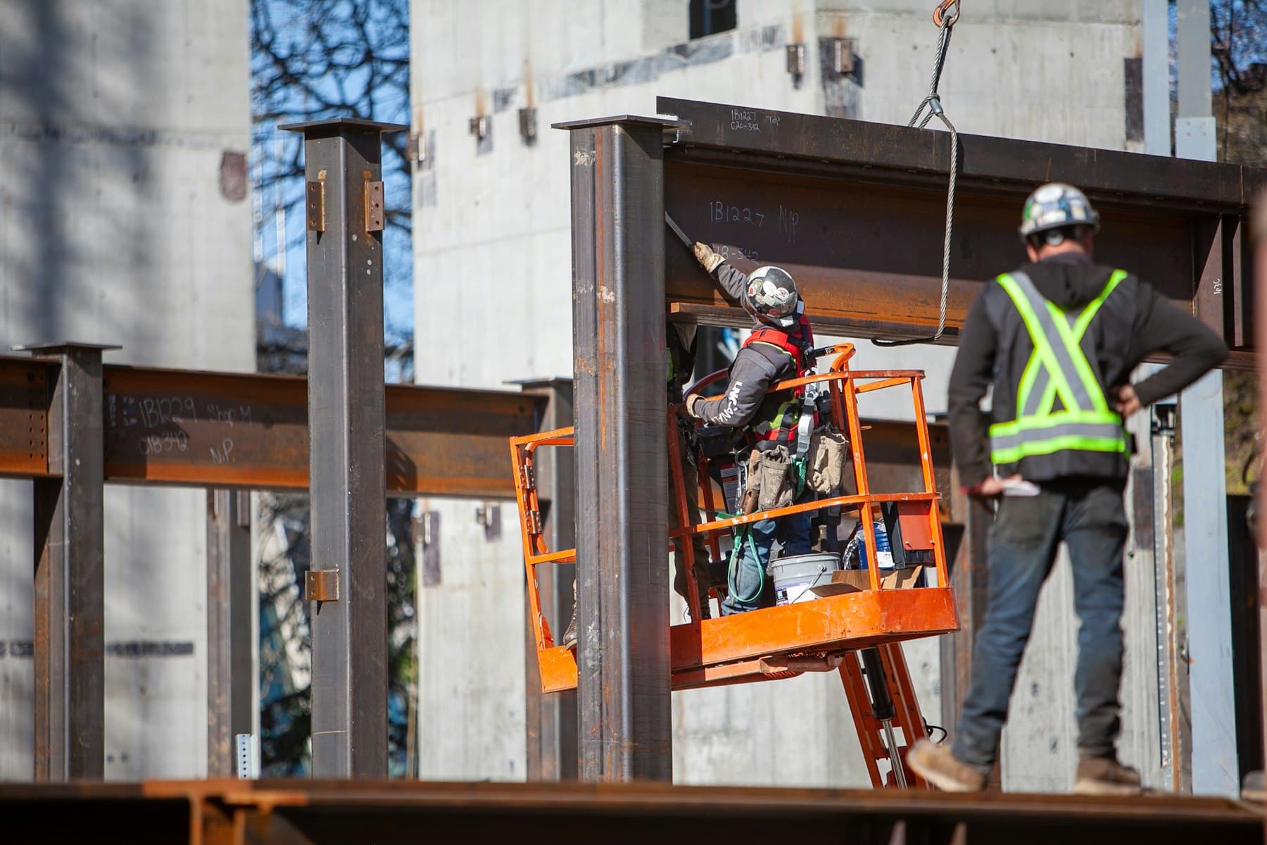 Ironworkers installing structural steel beams on a building frame